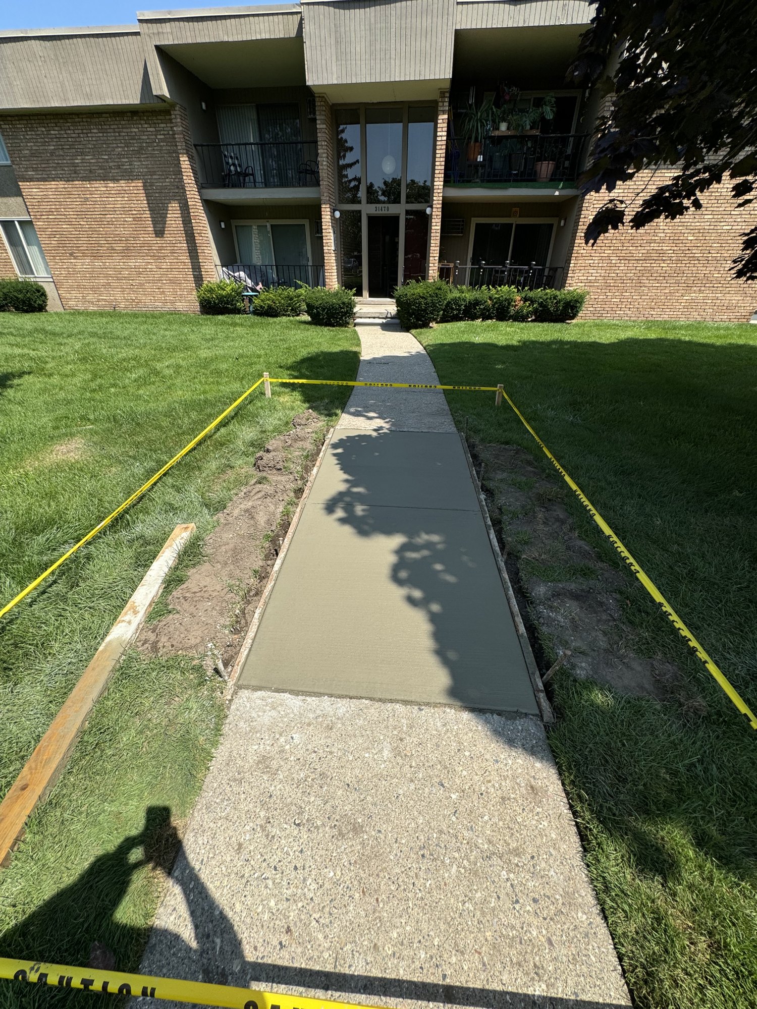 Newly placed concrete entry walkway leading to a building entrance