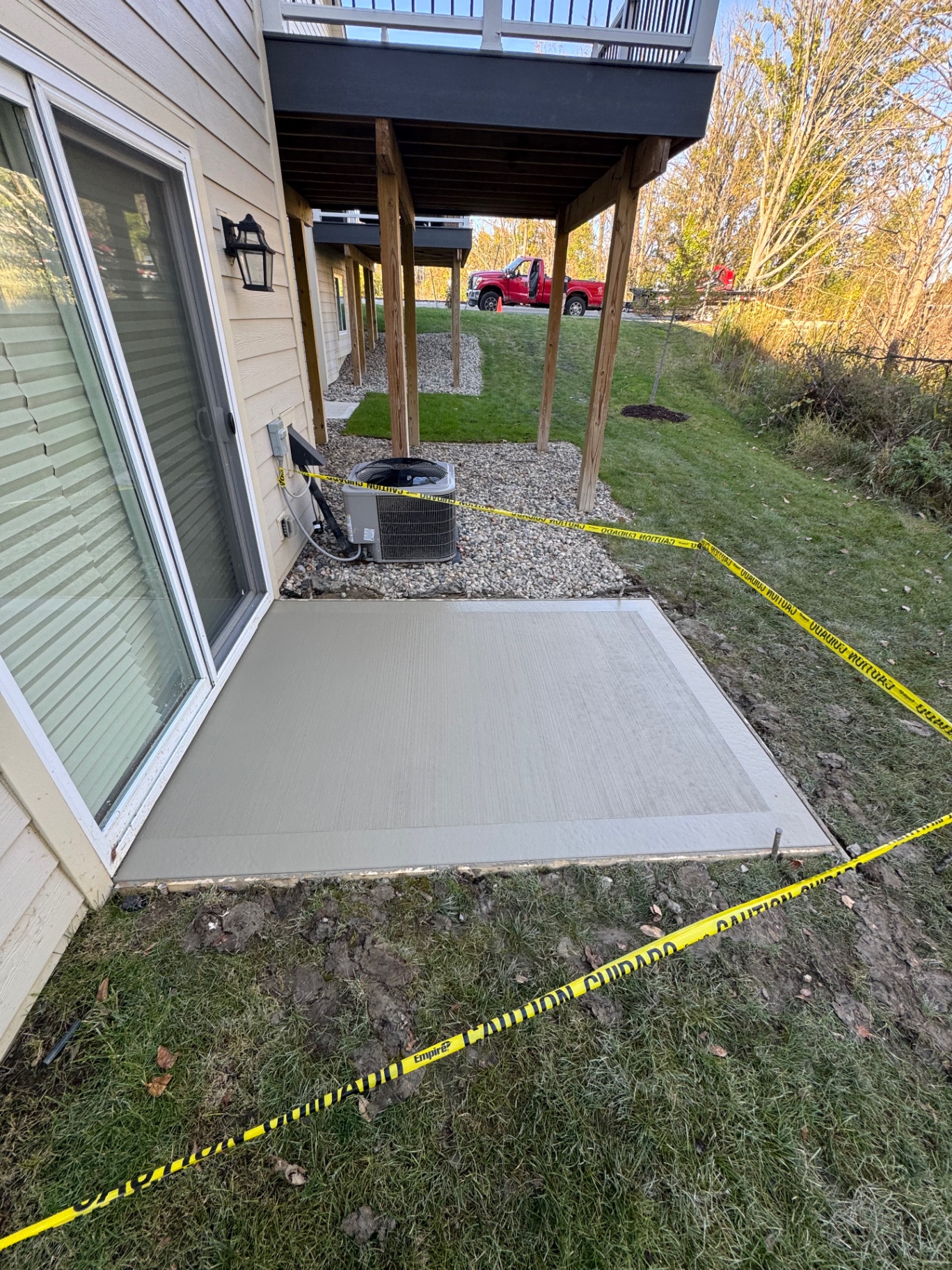 Broom-finish patio with a contrasting smooth border under a raised deck