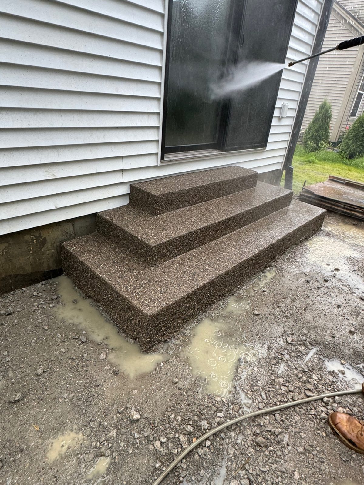 Exposed aggregate concrete entry steps being rinsed during the finishing process